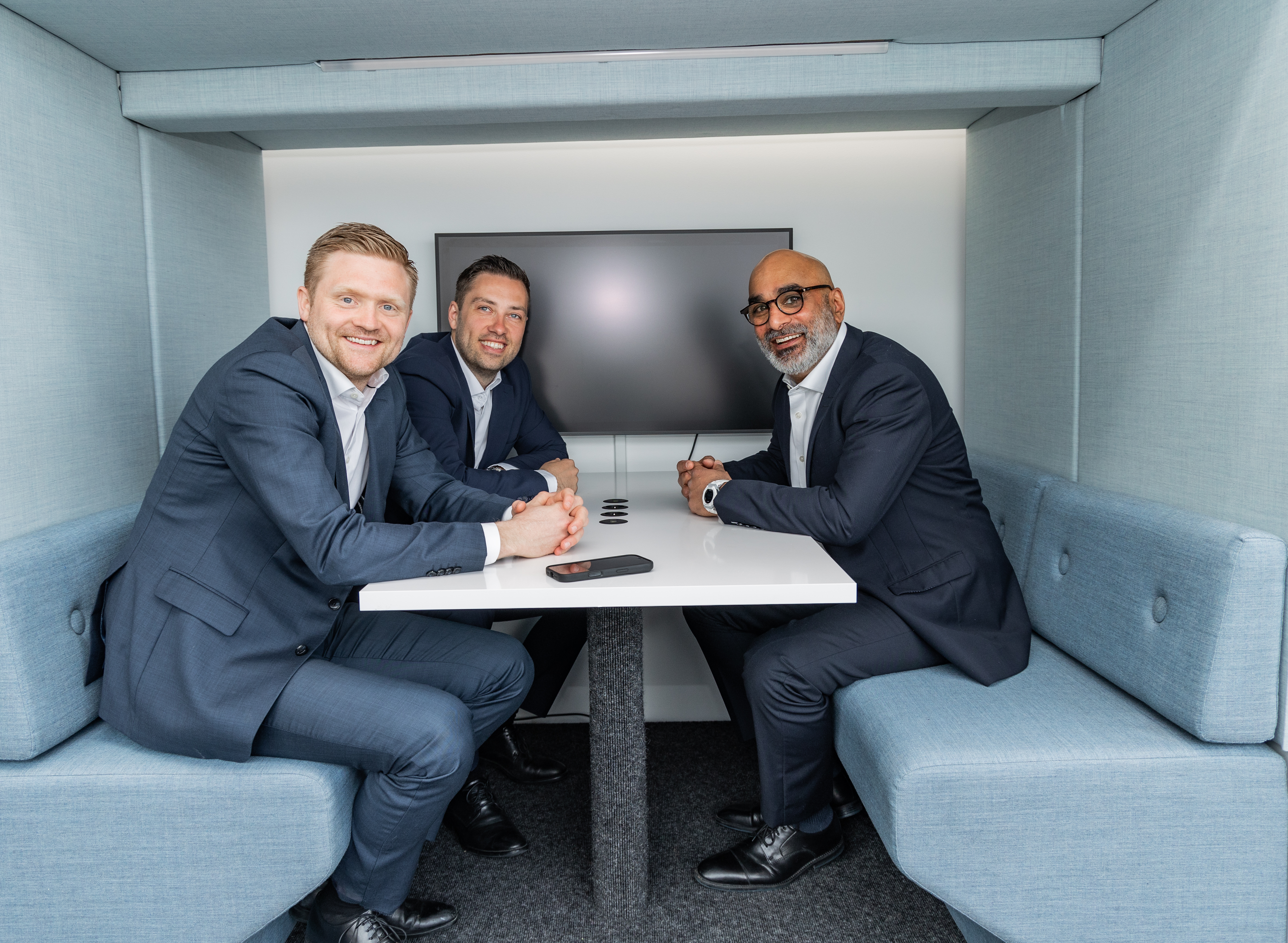 Tre personer sitter i en bås